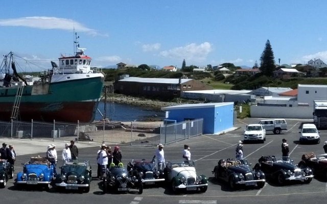Die pragtige groep Morgan-motors wat Gansbaai besoek het, staan hier “in gelid” in Gansbaai hawe geparkeer vir ‘n amptelike foto-sessie. Die besoek van 2 dae aan Gansbaai was deel van hulle Overberg-toer van sowat 500km van “easy topless driving”, vanaf Somerset-Wes na Agulhas en terug.